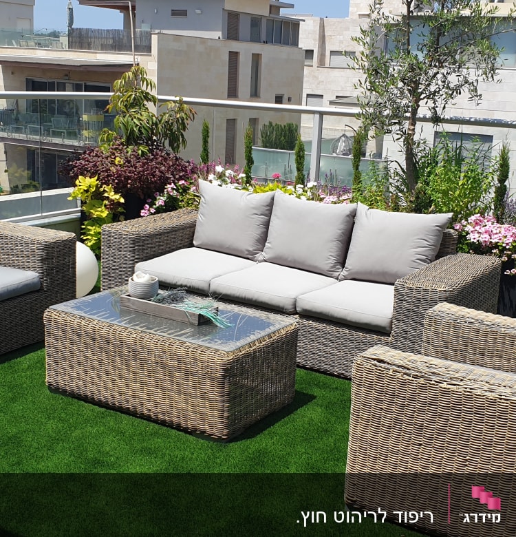 ריהוט גן עם כריות אפורות על דשא סינתטי